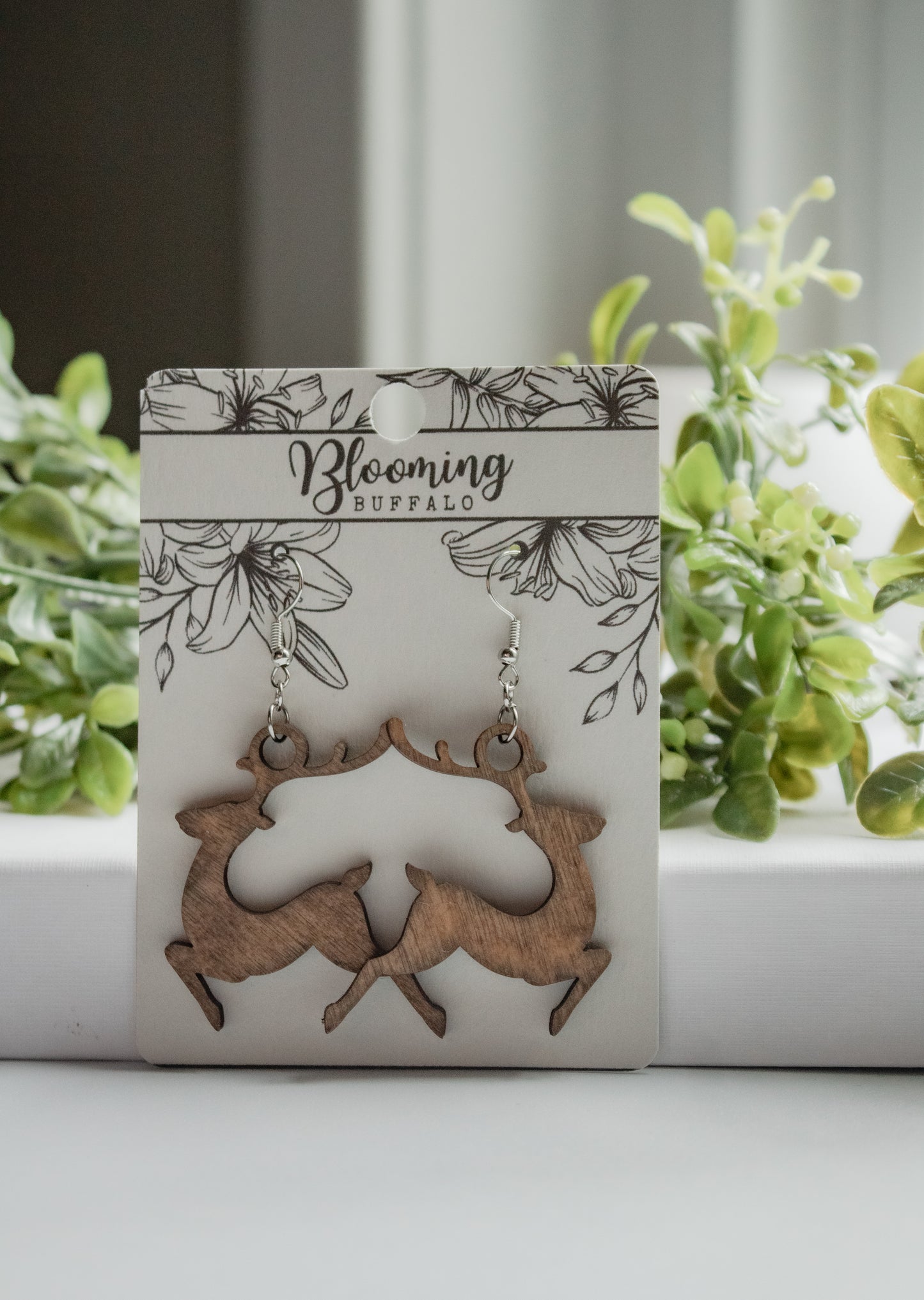 medium toned wooden reindeer dangle earrings on Blooming Buffalo branded earring card