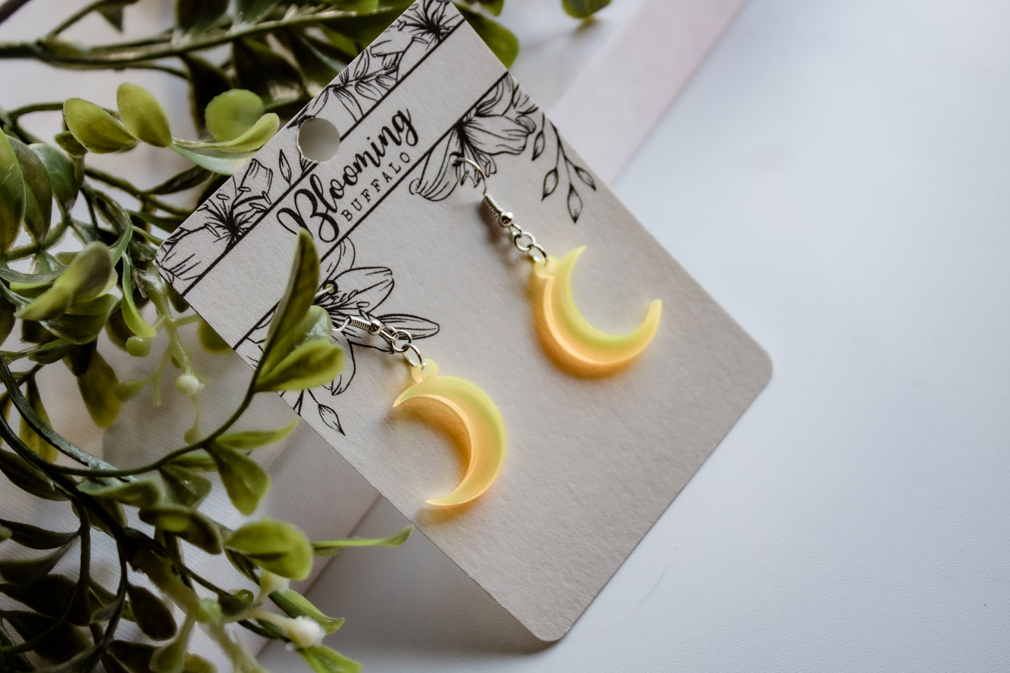 fluorescent yellow crescent moon dangle earrings on Blooming Buffalo branded earring card