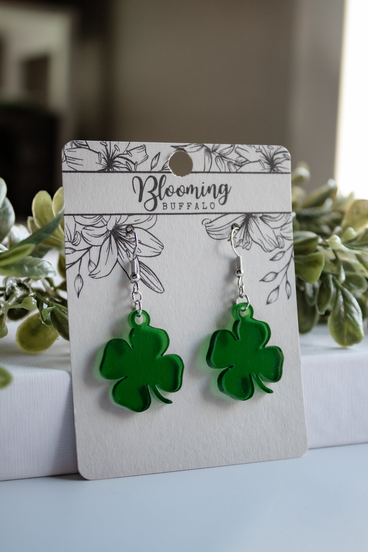 translucent green four-leaf clover shamrock dangle earrings on Blooming Buffalo branded earring card