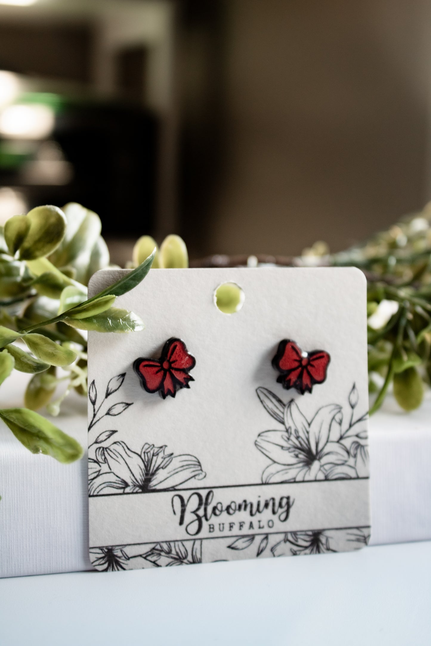 red and black gift bow stud earrings on Blooming Buffalo branded earring card