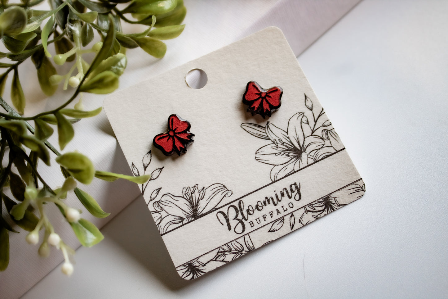red and black gift bow stud earrings on Blooming Buffalo branded earring card