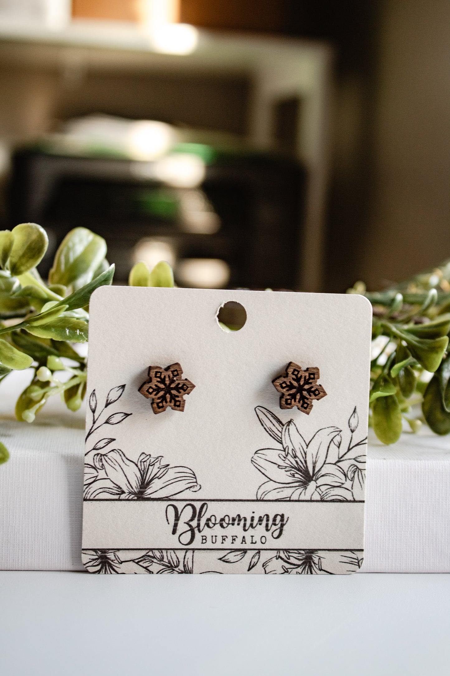 wooden snowflake stud earrings on a Blooming Buffalo branded earring card