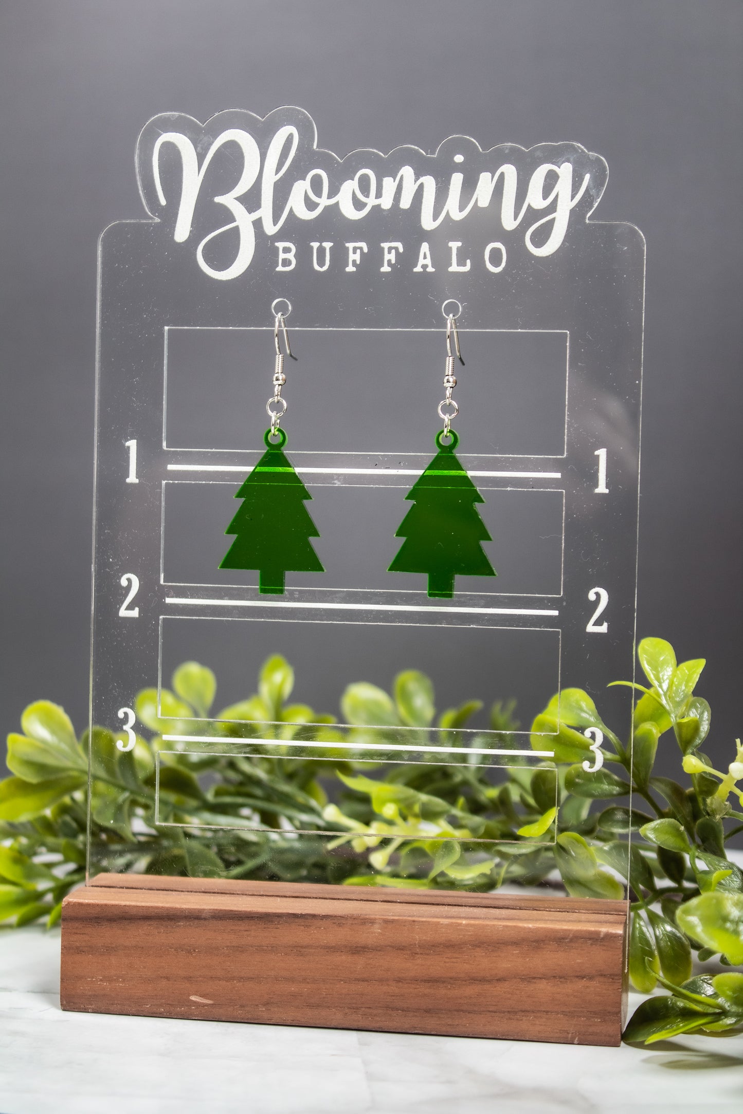 translucent green evergreen winter tree dangle earrings on Blooming Buffalo branded earring stand