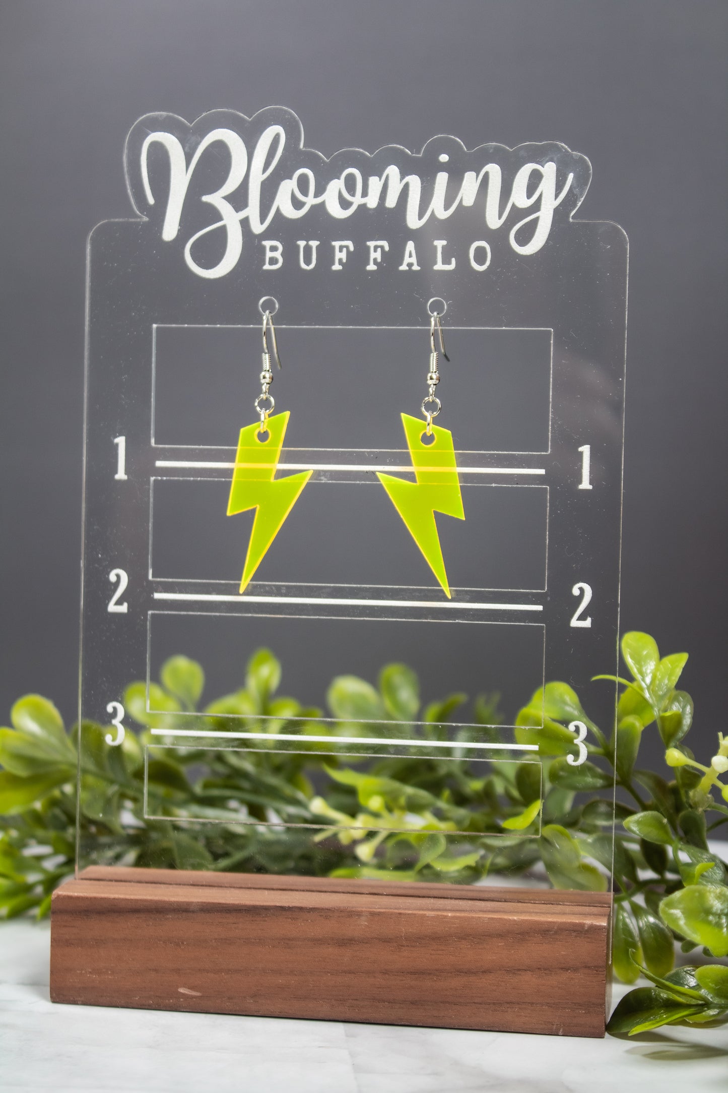 fluorescent yellow lightning bolt dangle earrings on Blooming Buffalo branded earring stand