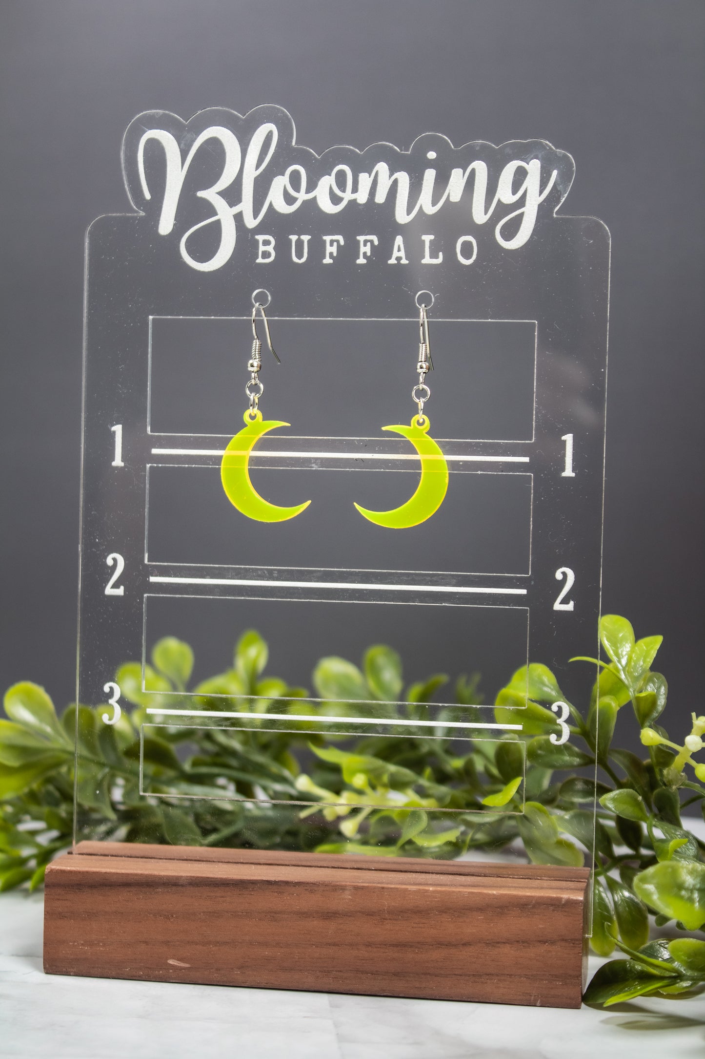 fluorescent yellow crescent moon dangle earrings on Blooming Buffalo branded earring stand