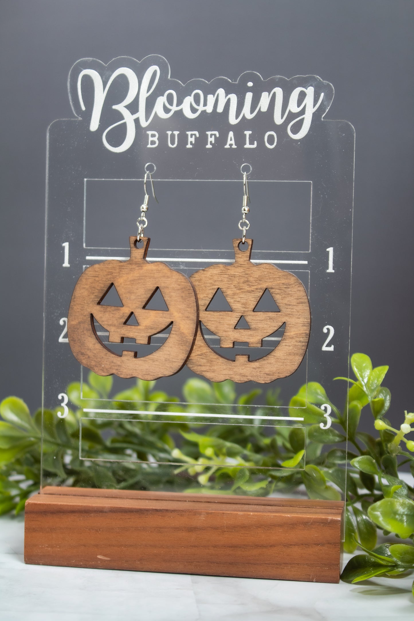 medium toned wood jack-o-lantern dangle earrings on a Blooming Buffalo display showing 2 inches