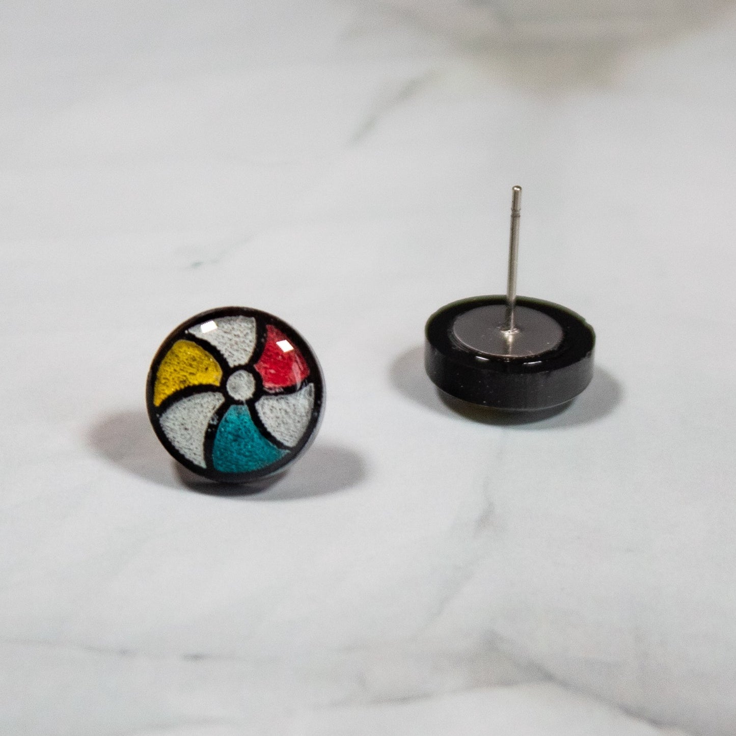 Red, White, Yellow and blue beach ball stud earring on white marbled background